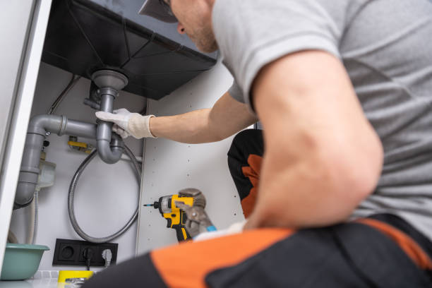 caucasian plumber performing quick kitchen sink drain fix